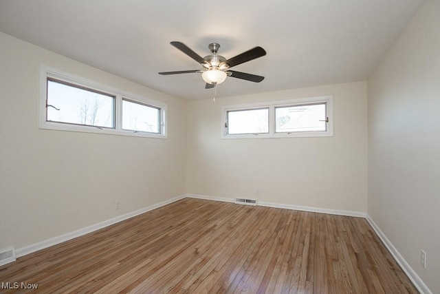 empty room with ceiling fan and light hardwood / wood-style floors