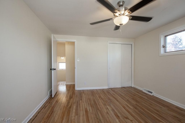 unfurnished bedroom featuring wood-type flooring, a closet, and ceiling fan