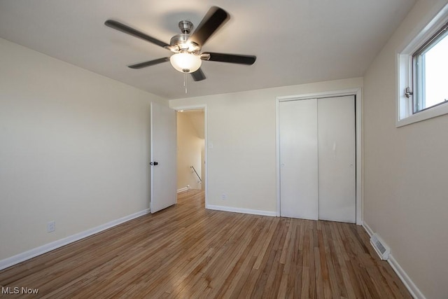 unfurnished bedroom featuring ceiling fan, a closet, and light hardwood / wood-style flooring