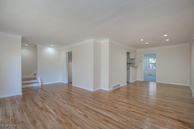 unfurnished room with light wood-type flooring and ornamental molding