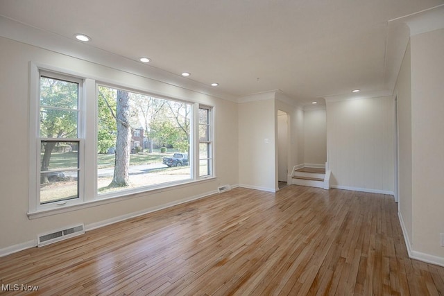 unfurnished living room featuring crown molding and light hardwood / wood-style flooring