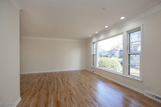 empty room featuring light hardwood / wood-style floors and ornamental molding