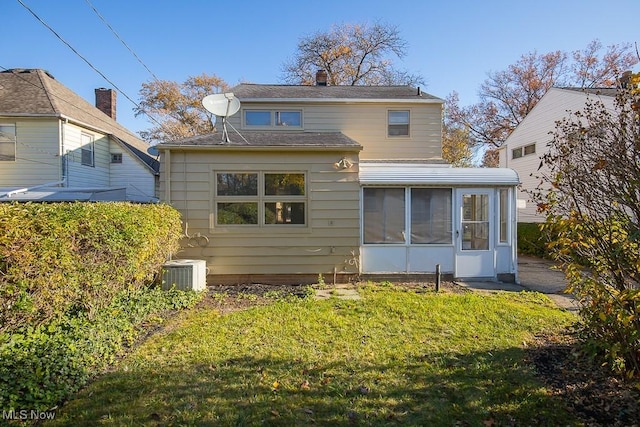 back of property with a lawn, a sunroom, and cooling unit