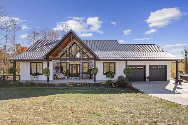 modern inspired farmhouse featuring a front lawn, covered porch, and a garage