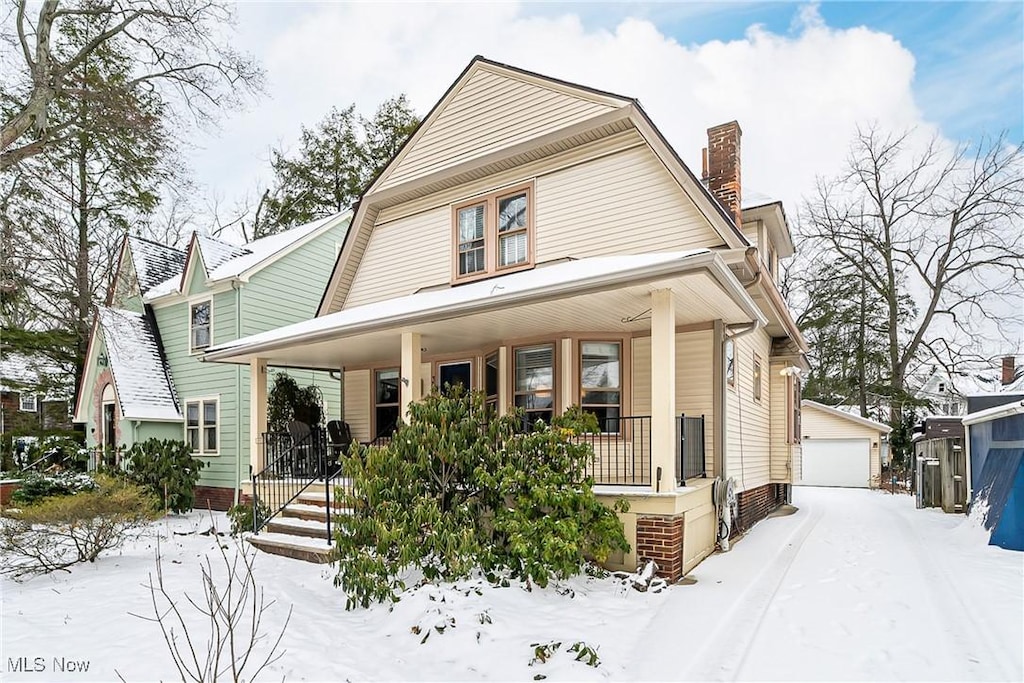 view of front of house featuring covered porch, an outdoor structure, and a garage