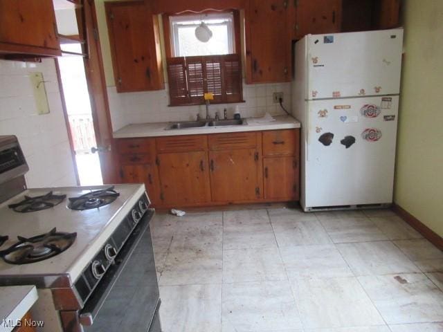 kitchen with white appliances, sink, a wealth of natural light, and tasteful backsplash