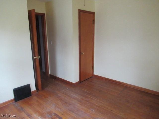 spare room featuring dark wood-type flooring