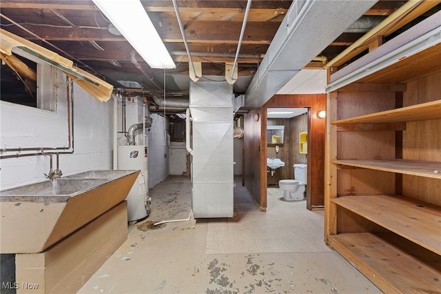 basement featuring gas water heater, heating unit, and wood walls