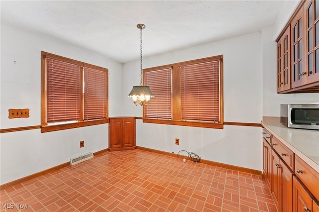 unfurnished dining area with a notable chandelier