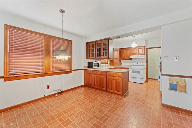 kitchen featuring electric range, sink, a notable chandelier, kitchen peninsula, and pendant lighting