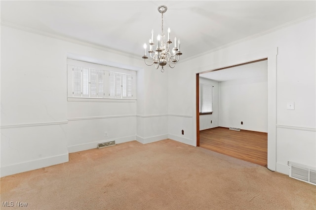 carpeted empty room with an inviting chandelier and ornamental molding