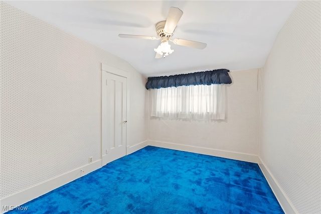 empty room with ceiling fan, carpet floors, and lofted ceiling