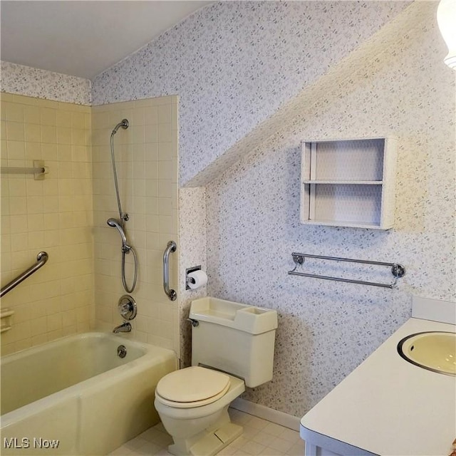 full bathroom with tile patterned floors, vanity, tiled shower / bath, and toilet