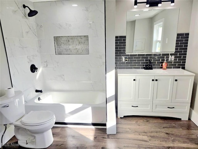 full bathroom featuring tiled shower / bath combo, tasteful backsplash, toilet, and hardwood / wood-style flooring