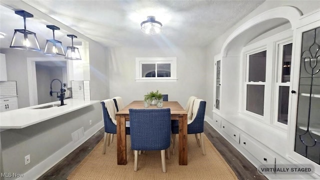 dining space with dark wood-type flooring and sink