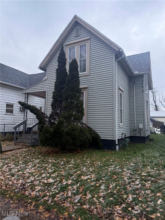 view of side of home with a yard