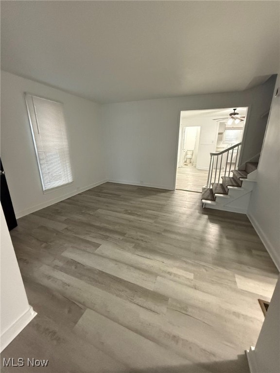 unfurnished living room with wood-type flooring and ceiling fan