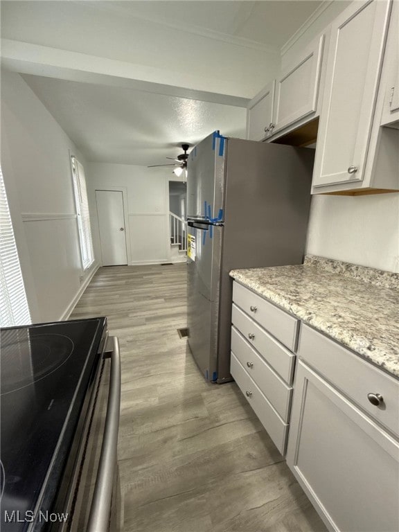 kitchen with white cabinets, electric range, ceiling fan, light stone countertops, and stainless steel refrigerator