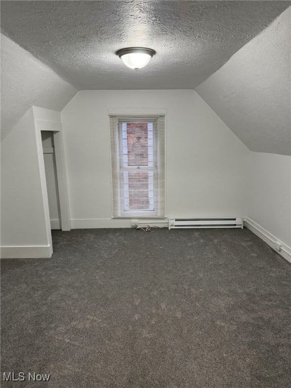 bonus room featuring dark colored carpet, a textured ceiling, a baseboard radiator, and vaulted ceiling