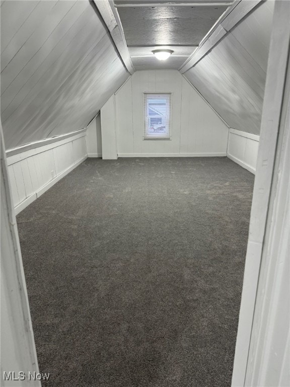 bonus room featuring dark colored carpet and vaulted ceiling