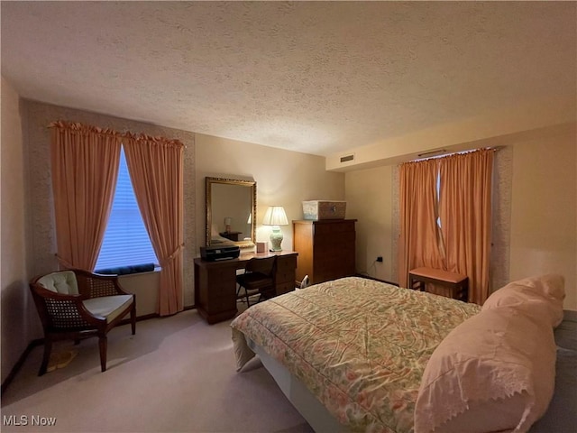 bedroom with light colored carpet and a textured ceiling