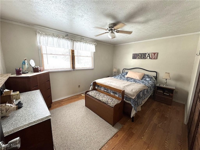 bedroom with a textured ceiling, dark wood-type flooring, ceiling fan, and crown molding