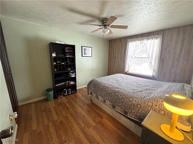 bedroom featuring ceiling fan, wood-type flooring, and a textured ceiling