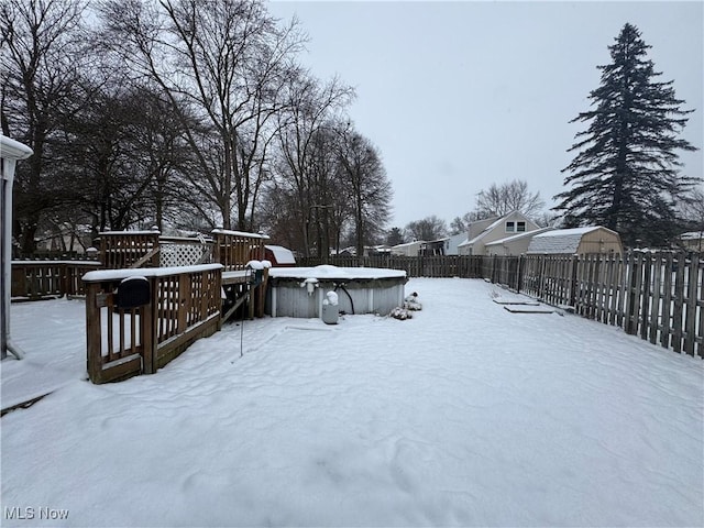 yard layered in snow featuring a deck