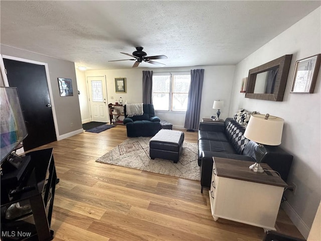 living room with ceiling fan, hardwood / wood-style floors, and a textured ceiling