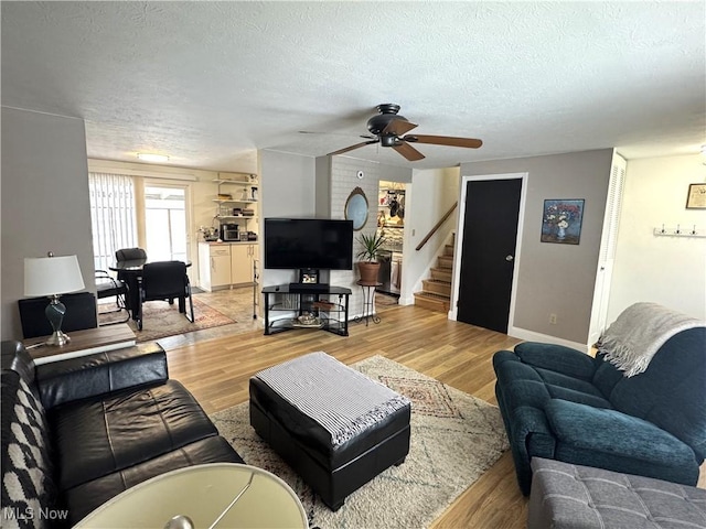 living room featuring a textured ceiling, light hardwood / wood-style flooring, and ceiling fan