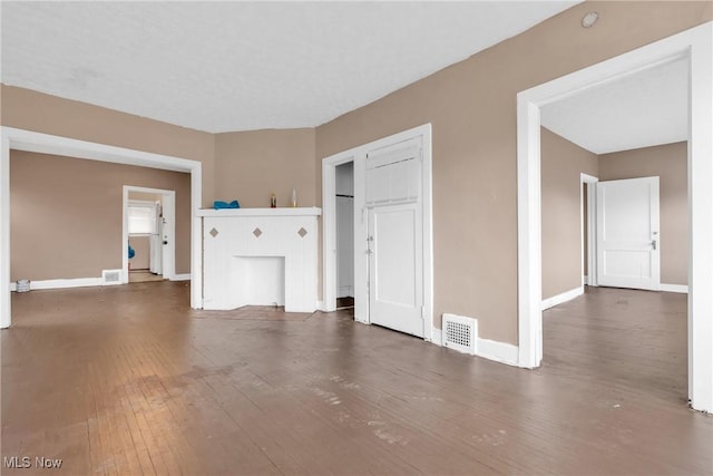 unfurnished living room with a fireplace and dark hardwood / wood-style flooring