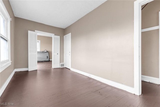 interior space with dark hardwood / wood-style floors and a wealth of natural light