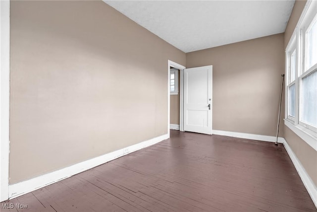 unfurnished room with dark wood-type flooring