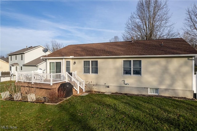 back of property with a lawn and a deck