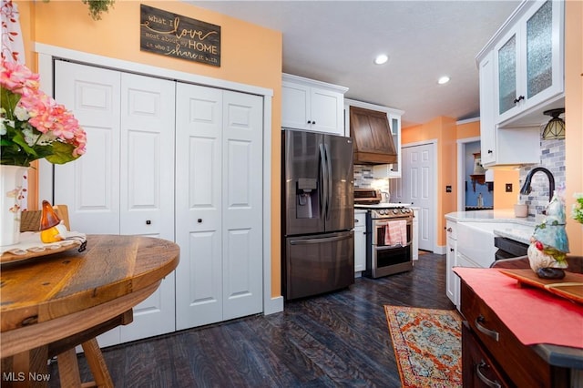 kitchen featuring stainless steel fridge, stove, premium range hood, white cabinets, and dark hardwood / wood-style floors