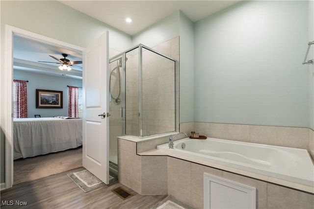 bathroom featuring hardwood / wood-style flooring, ceiling fan, and shower with separate bathtub