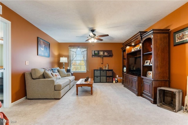 carpeted living room with a textured ceiling and ceiling fan