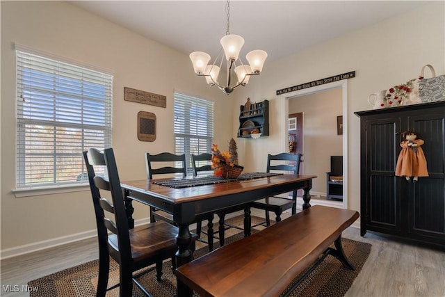 dining space with a chandelier and light hardwood / wood-style flooring