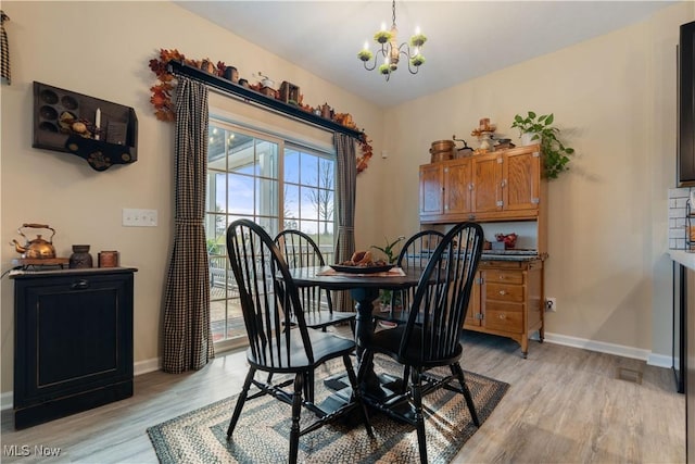 dining area with a chandelier and light wood-type flooring