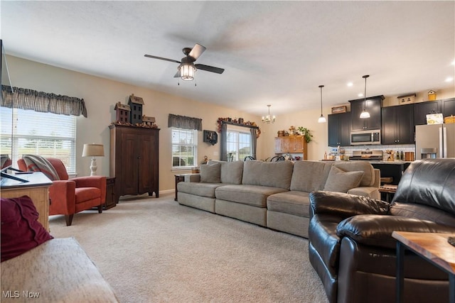 living room with light carpet and ceiling fan with notable chandelier