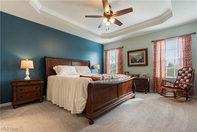 bedroom with ceiling fan, a raised ceiling, and light colored carpet