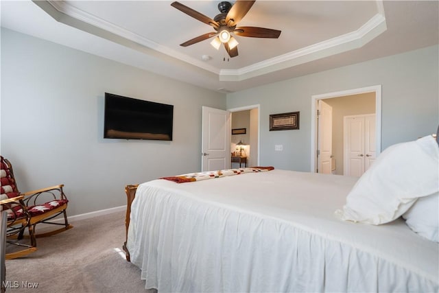 bedroom featuring carpet floors, a raised ceiling, and ceiling fan