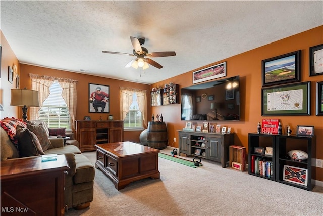 carpeted living room with ceiling fan and a textured ceiling