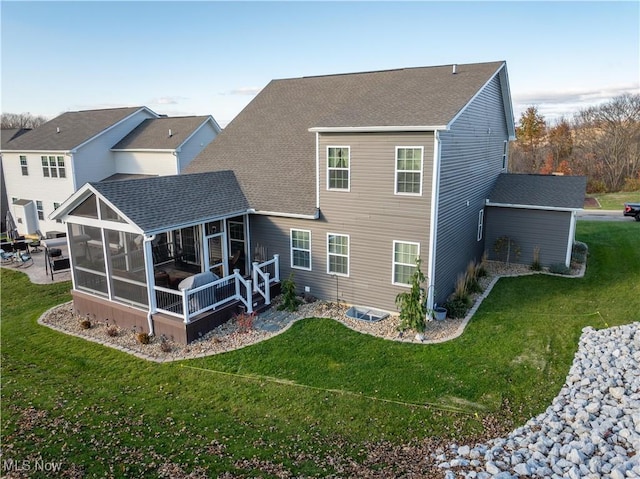 back of property with a lawn and a sunroom