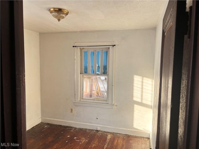 empty room with dark hardwood / wood-style flooring