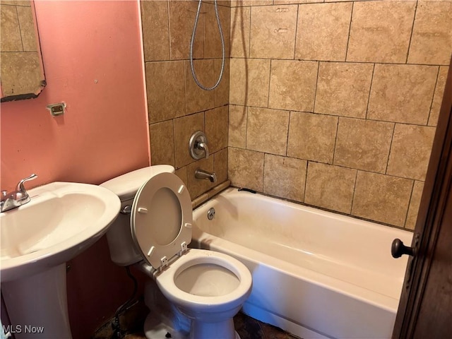 bathroom featuring toilet and tiled shower / bath