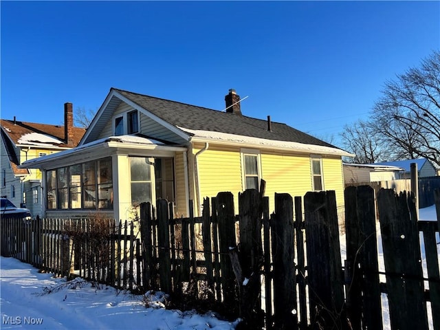 snow covered property featuring a sunroom