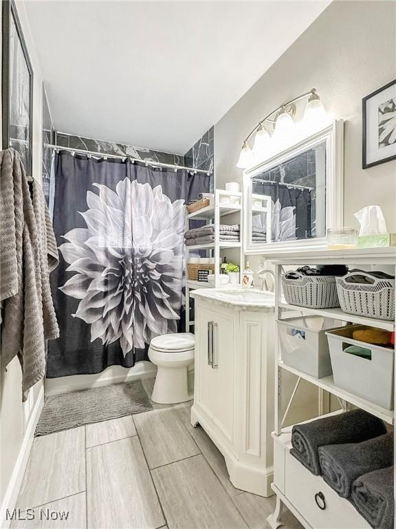 bathroom featuring curtained shower, vanity, and toilet