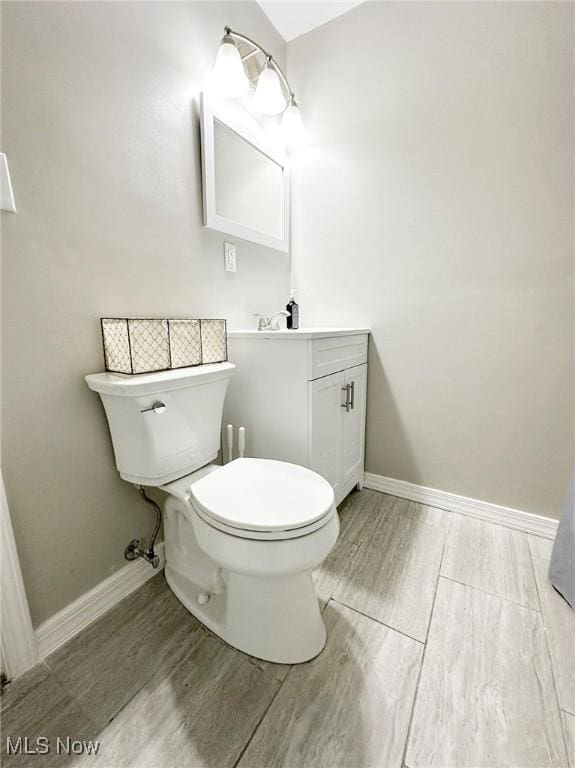 bathroom with vanity, wood-type flooring, and toilet