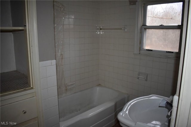 bathroom featuring shower / bath combination and tile walls